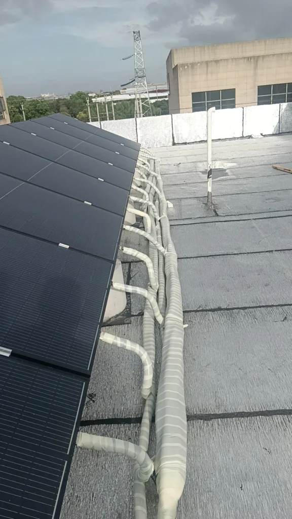 Residential brine-loop PVT collectors mounted on a rooftop, connected to a heat pump system for hot water and space heating