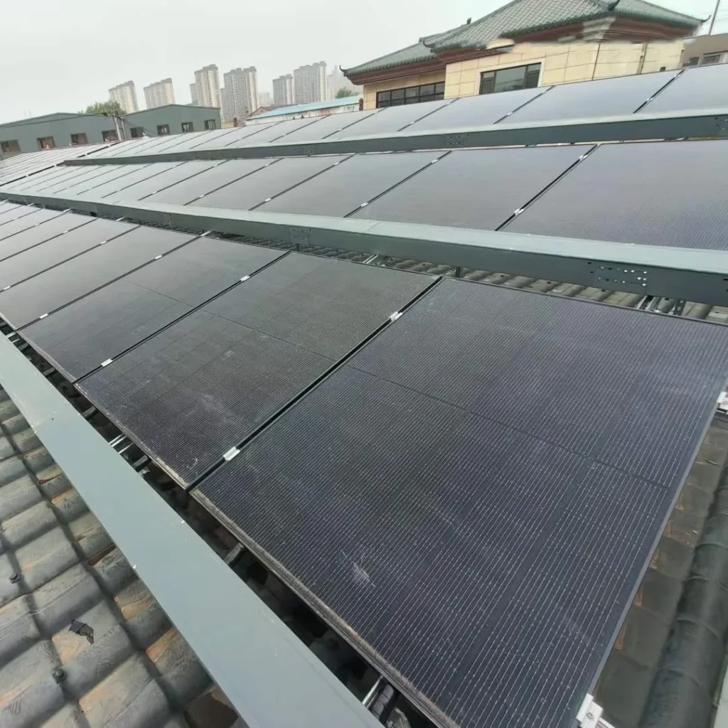 36-panel PVT collector array on a residential rooftop configured as a large-scale ASHP preheating retrofit