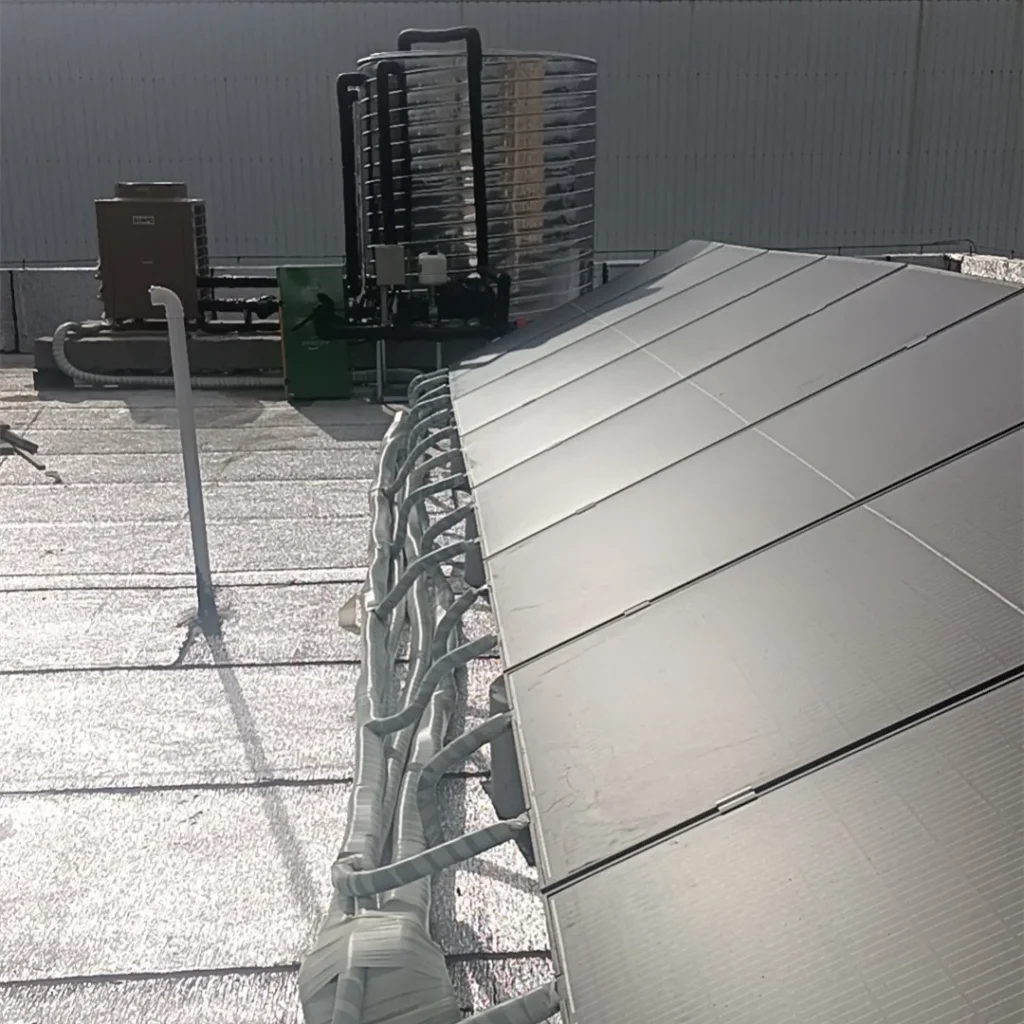 8-panel PVT collector array on a rooftop, integrated with a brine-to-water heat pump system